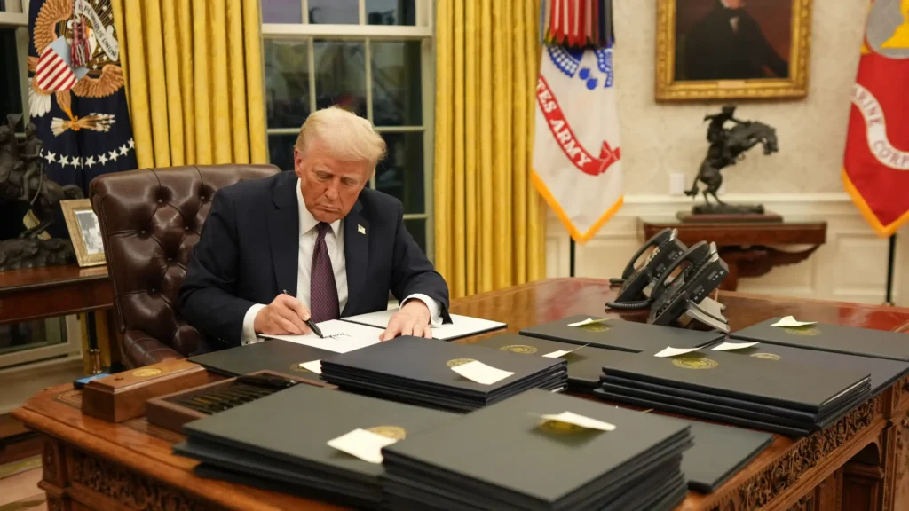 President at desk signing documents related to Trump tariffs